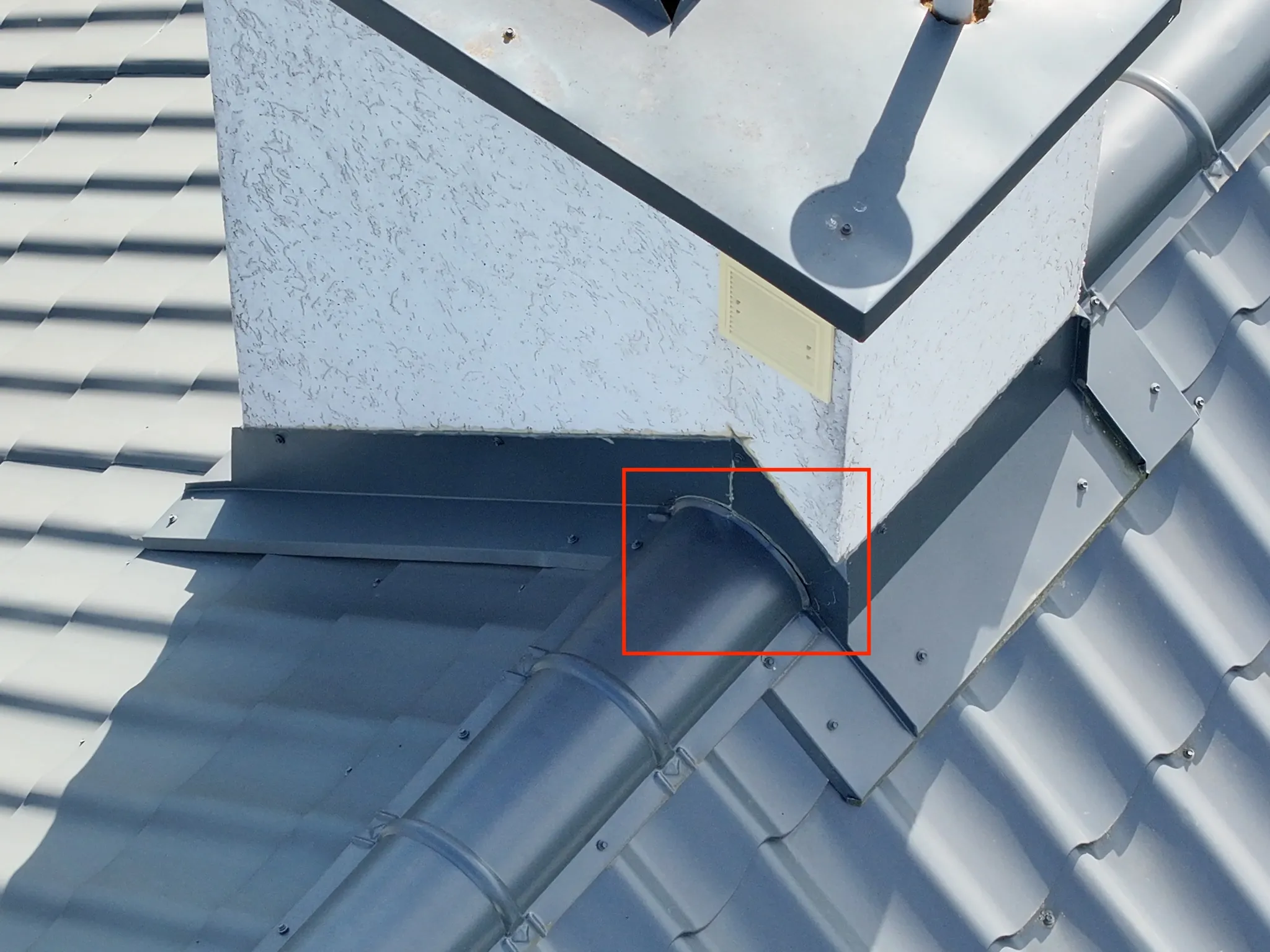Inspekcja dachu dronem — zbliżenie na komin z oznaczonym defektem